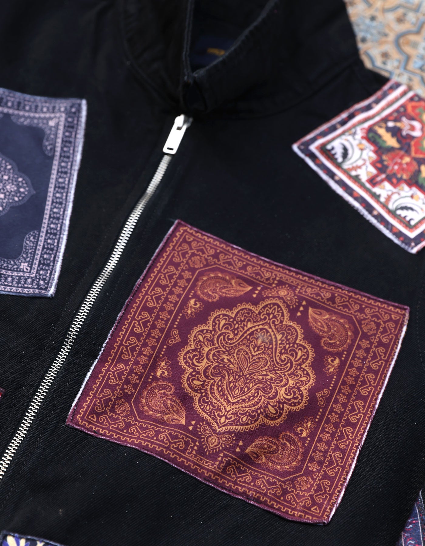 Black jacket with patterned patches on a textured surface