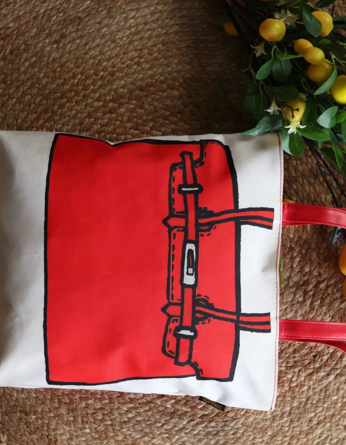 Red and black bag design on a white pillow with a textured brown background