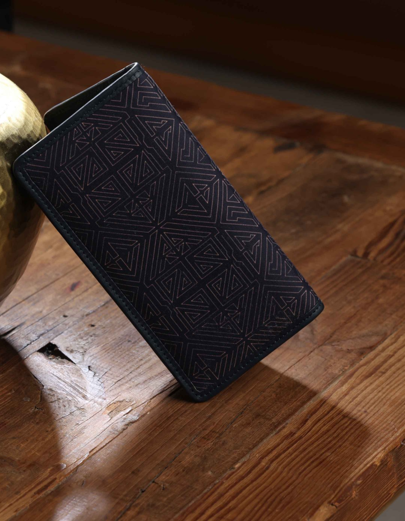 Black embossed wallet on a wooden surface