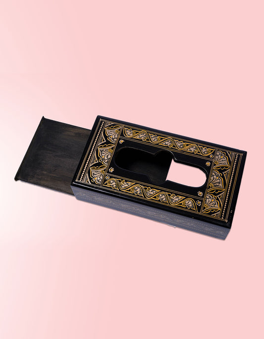 Decorative black and gold box on a pink background