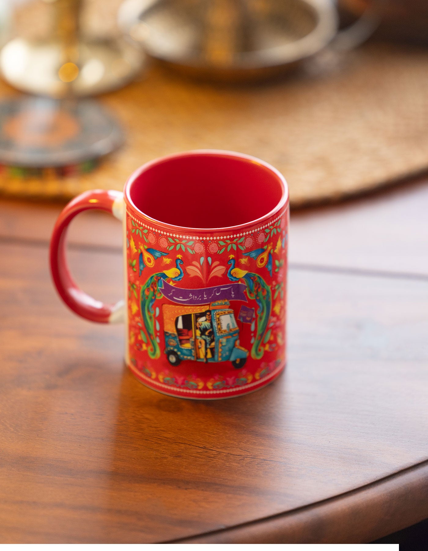 Red mug with colorful design on a wooden table