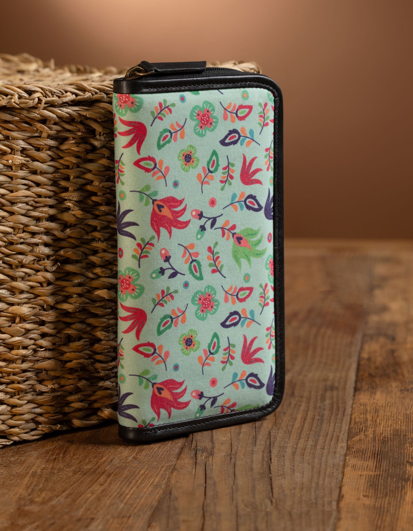 Floral patterned phone case on a wooden surface with a woven basket