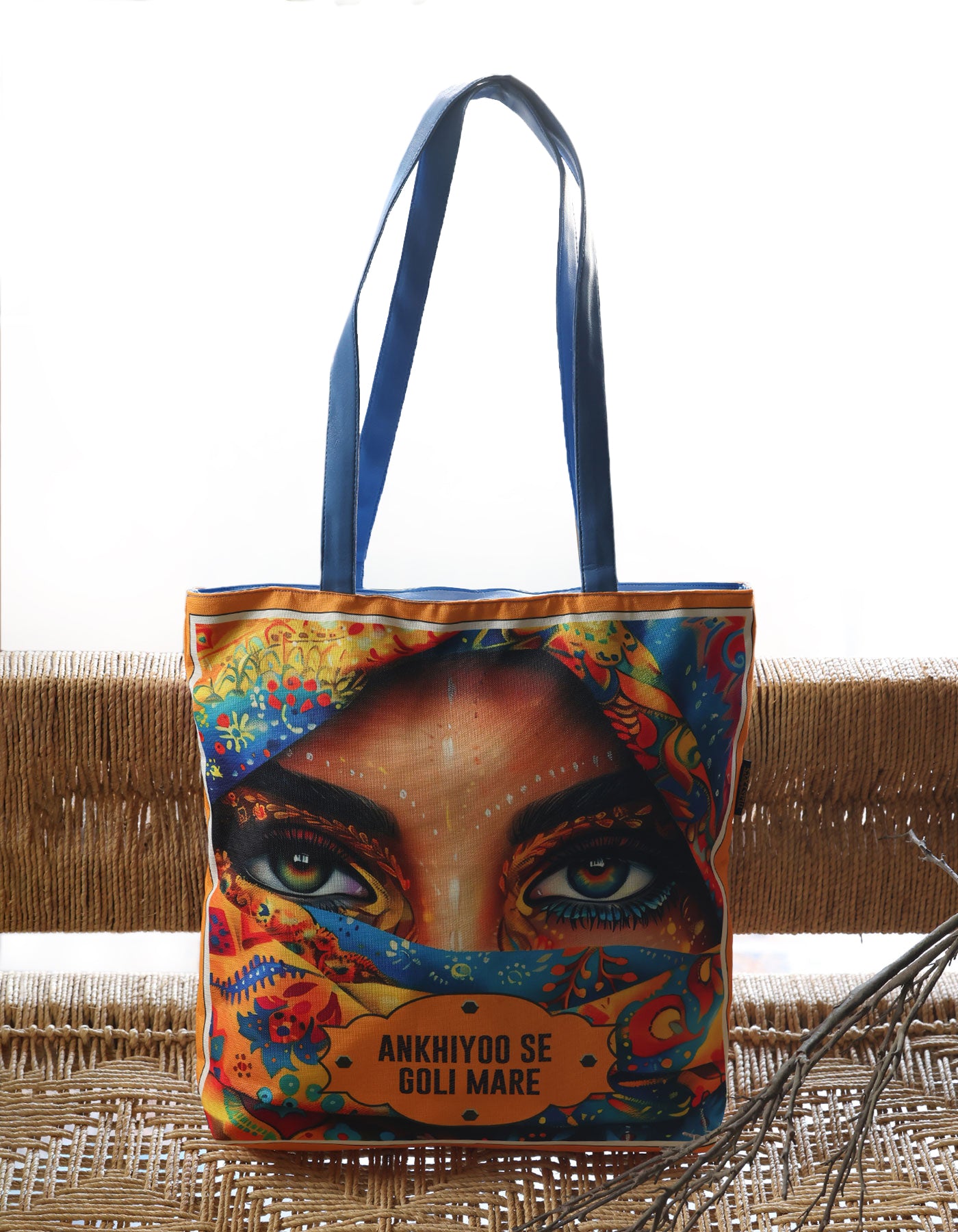 Tote bag with a colorful design of a face and text on a woven surface