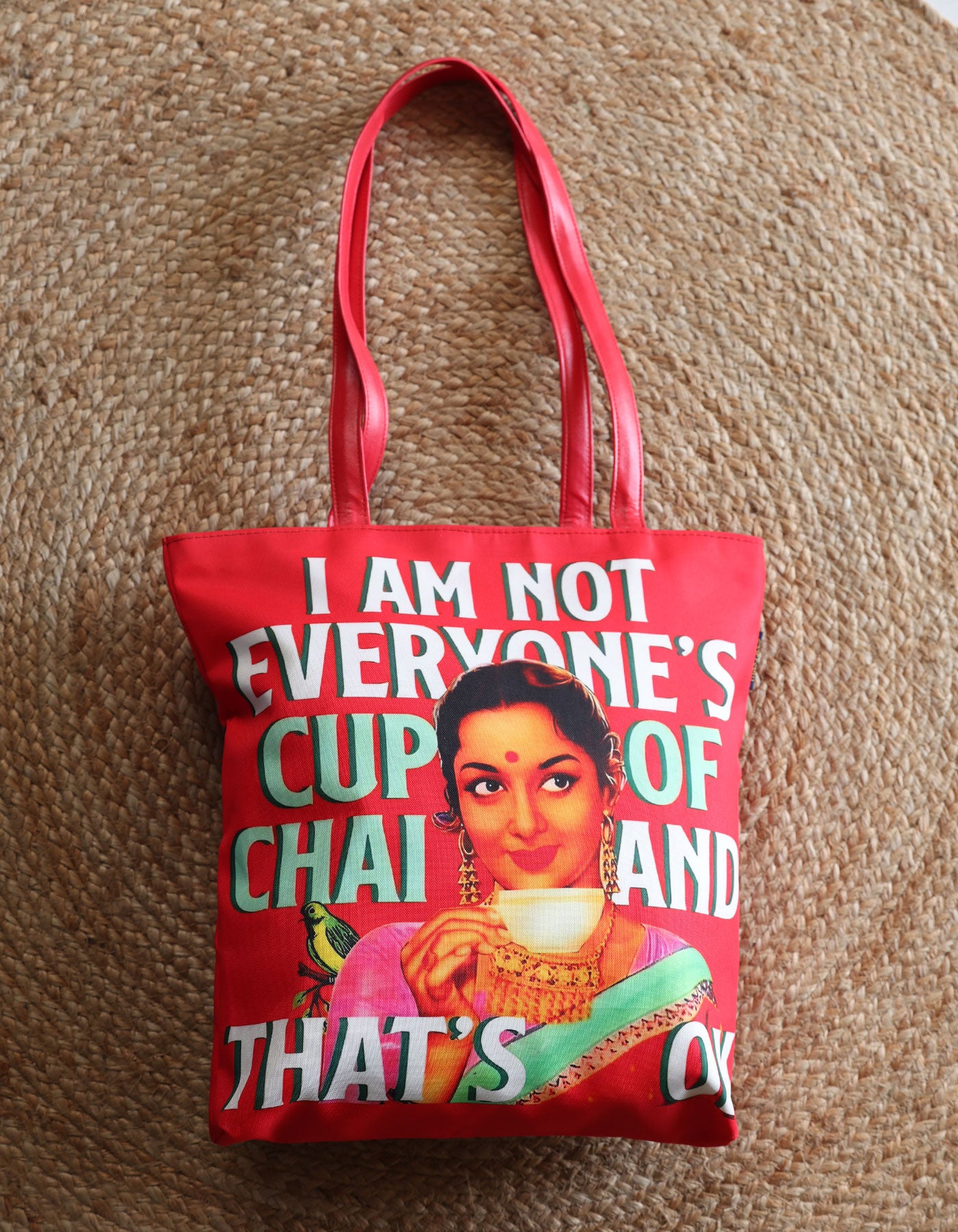 Red tote bag with a graphic of a woman holding a cup and text on a textured brown background