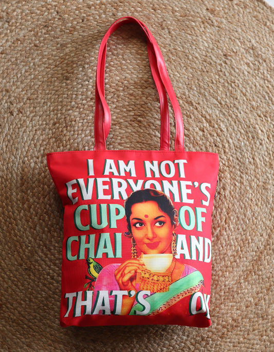 Red tote bag with a graphic of a woman holding a cup and text on a textured brown background