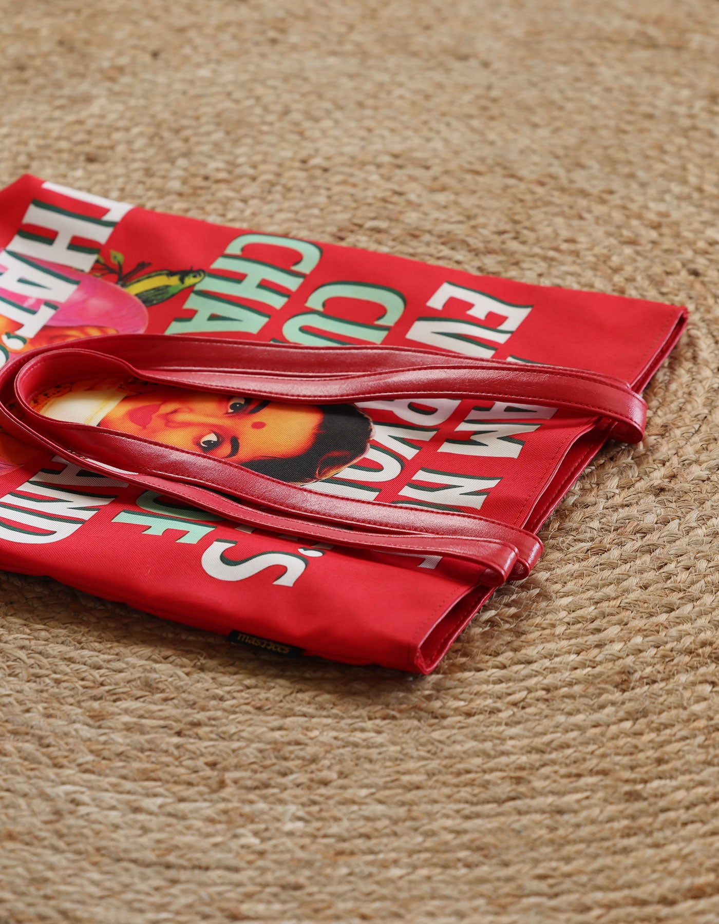 Red bag with text and a face graphic on a textured surface
