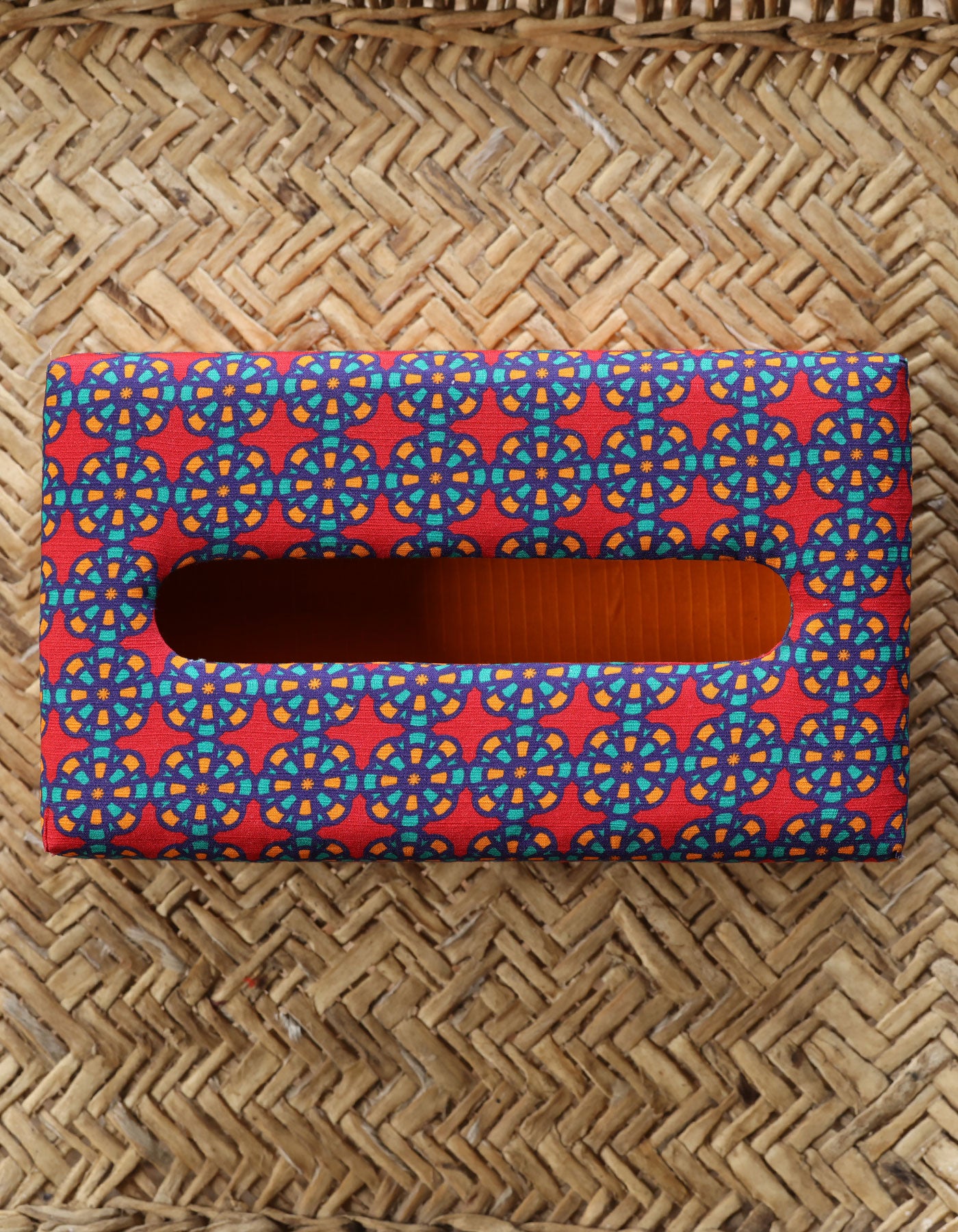 Rectangular tissue box cover with a colorful geometric pattern on a woven background
