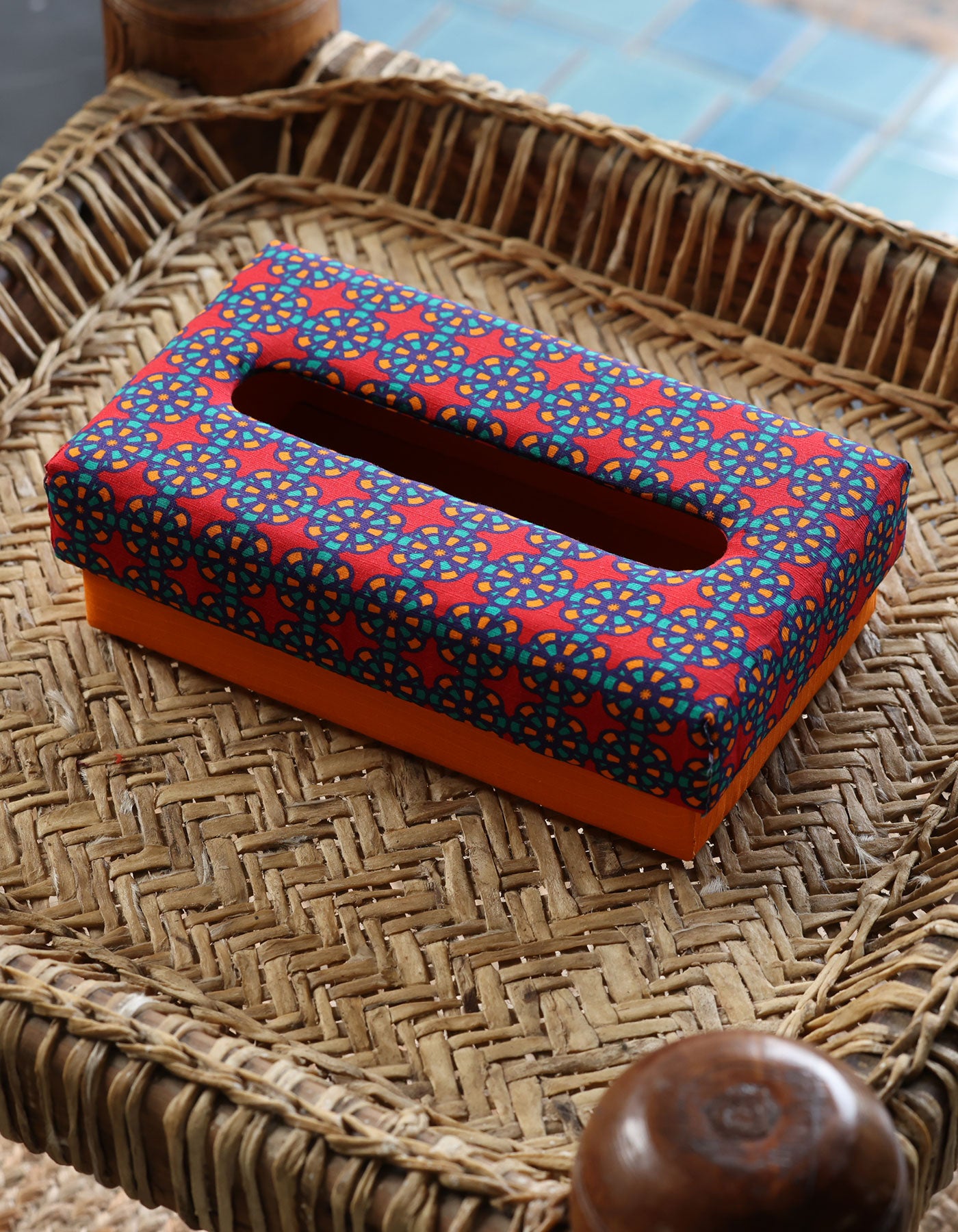 Decorative tissue box cover with colorful pattern on a woven surface