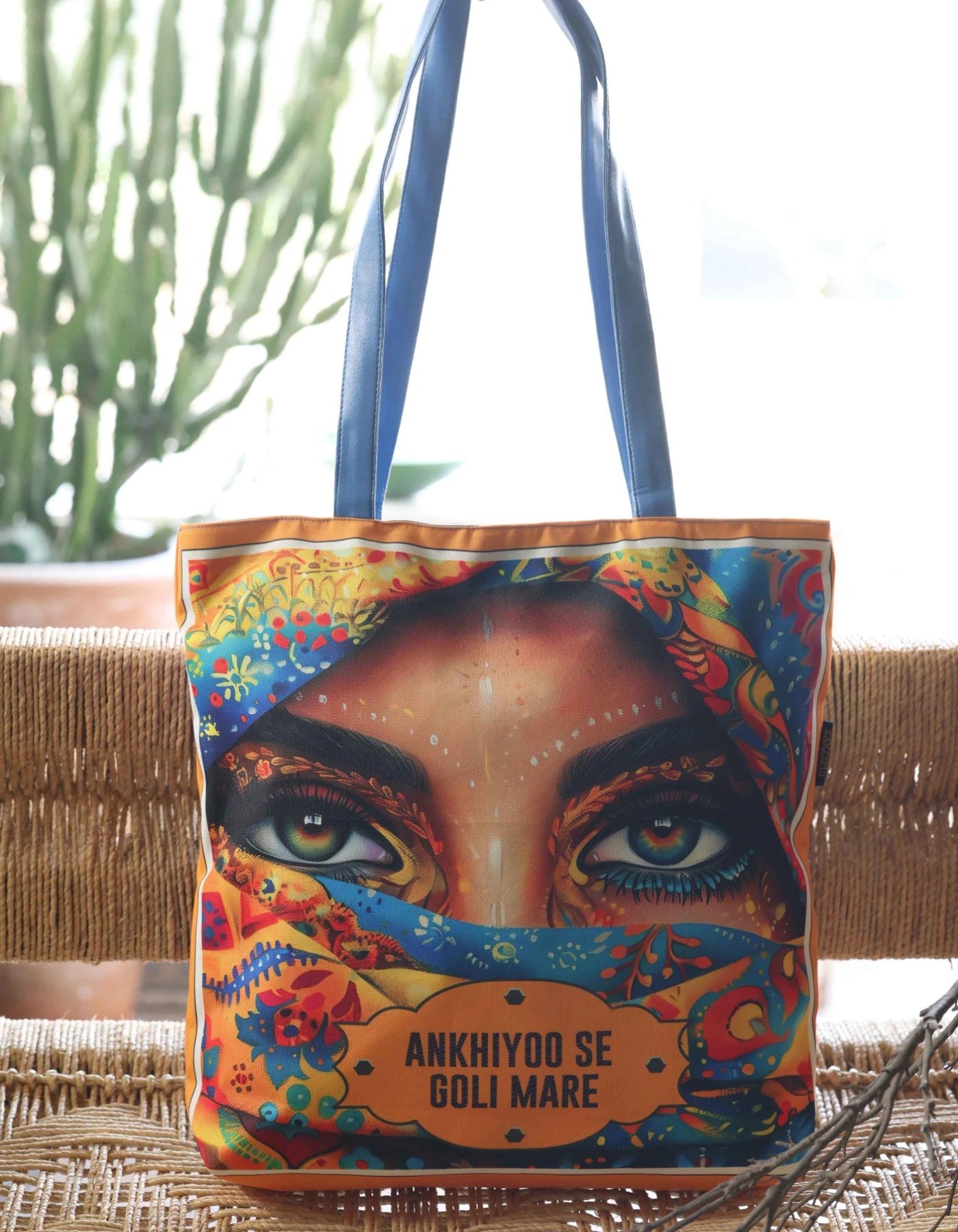 Colorful tote bag with a face design and text on a woven surface