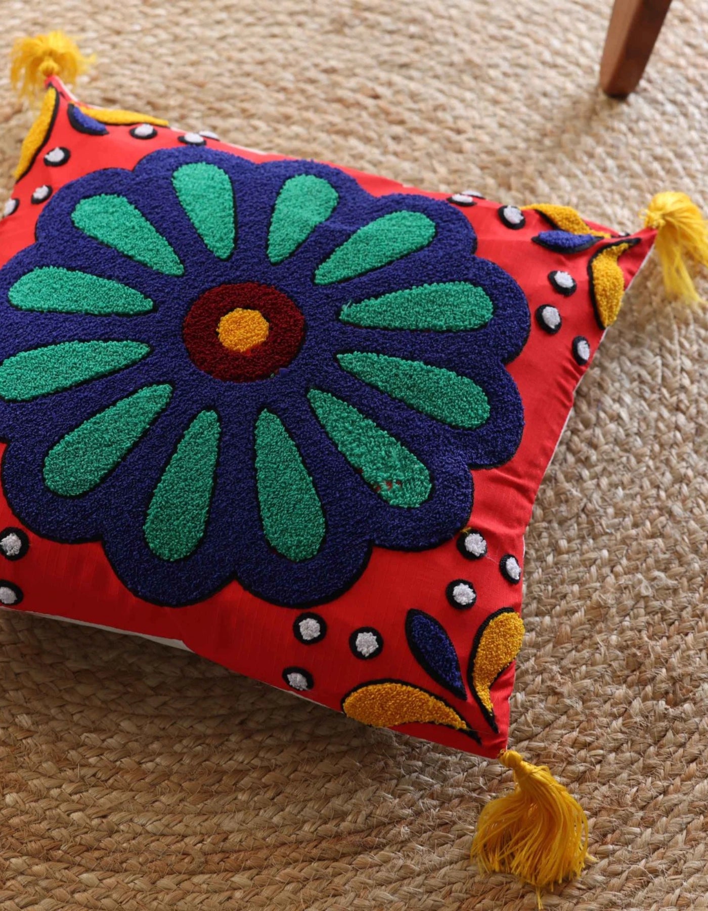 Decorative pillow with a colorful floral design on a beige carpet