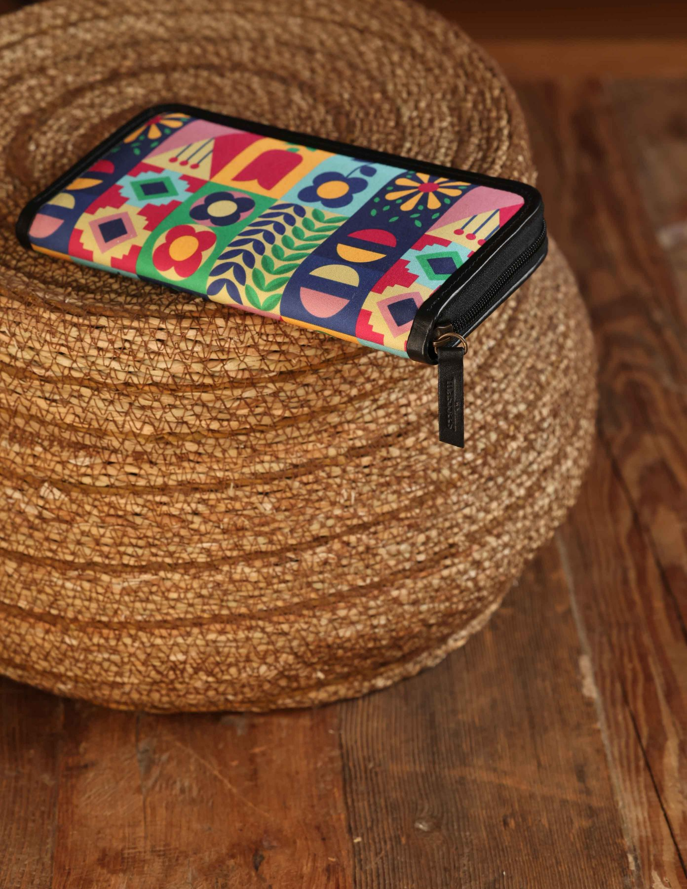Colorful geometric patterned pouch on a woven stool
