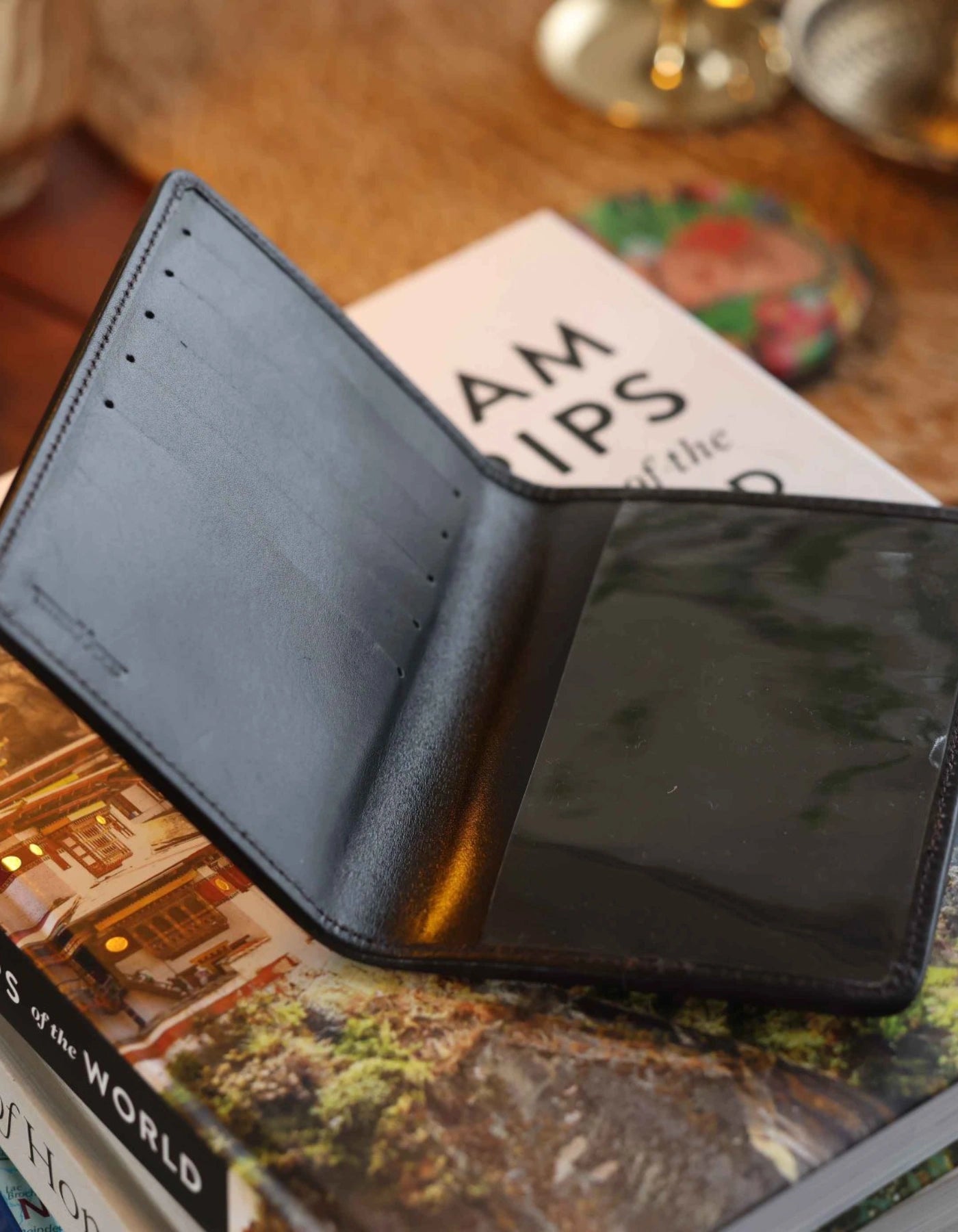 Black leather wallet on top of a book with a blurred background