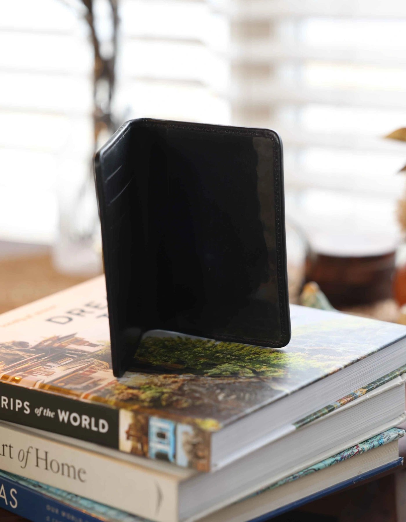 Black phone case on a stack of books with a blurred background