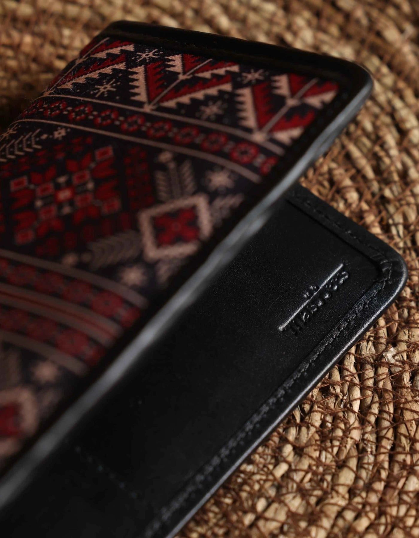 Black phone case with geometric pattern on a textured surface
