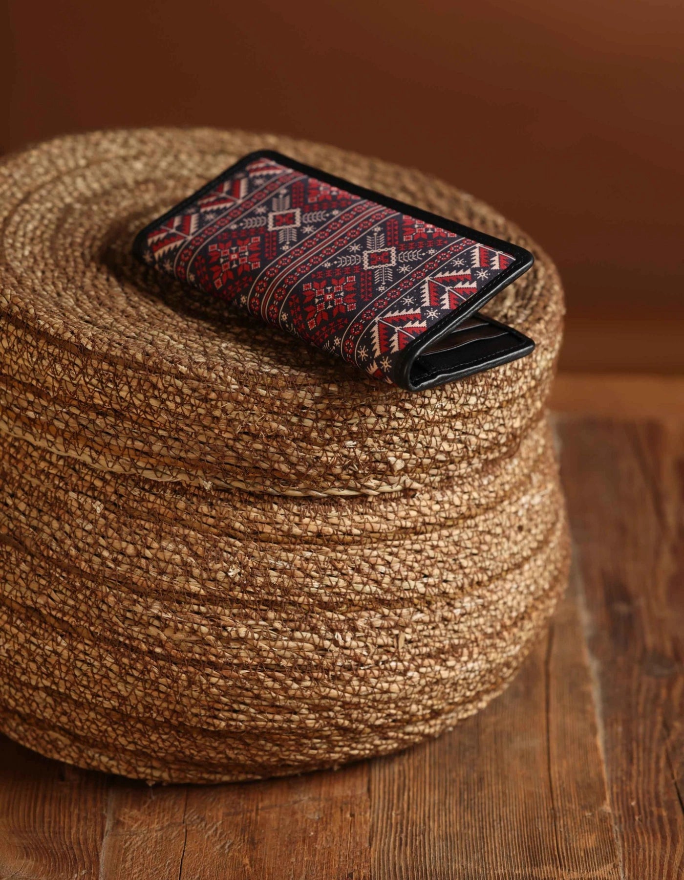 Decorative wallet with geometric pattern on a woven brown mat