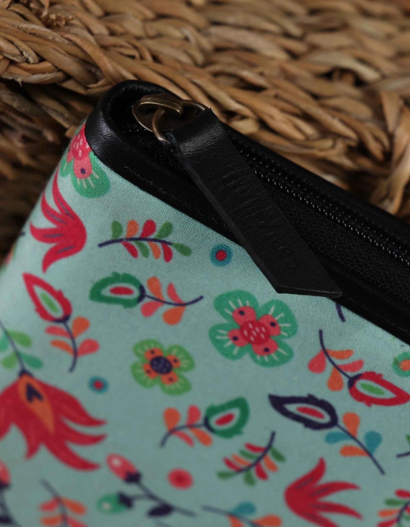 Floral-patterned pouch with a zipper on a woven surface