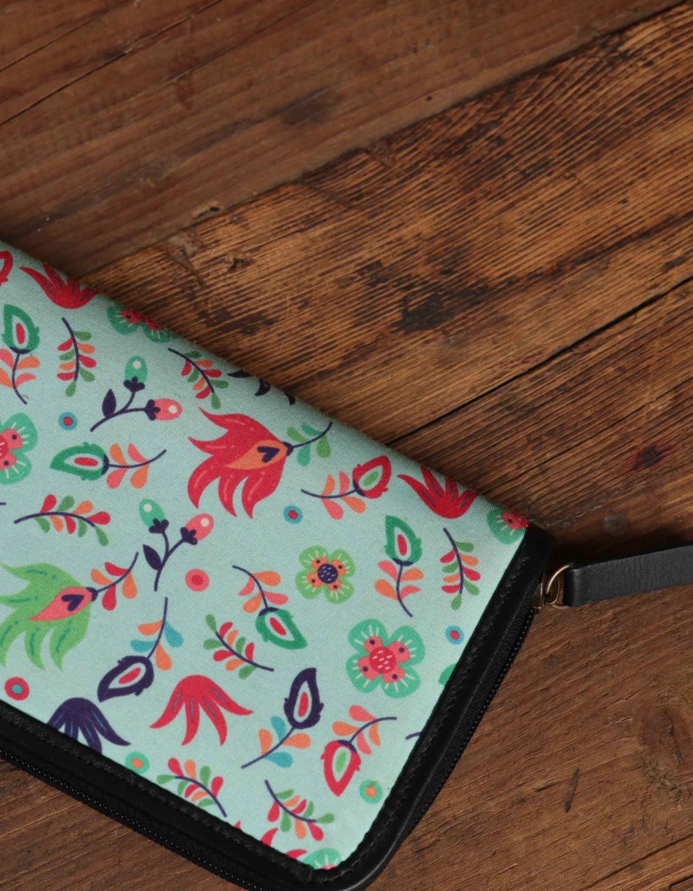 Floral patterned clutch bag on a wooden surface