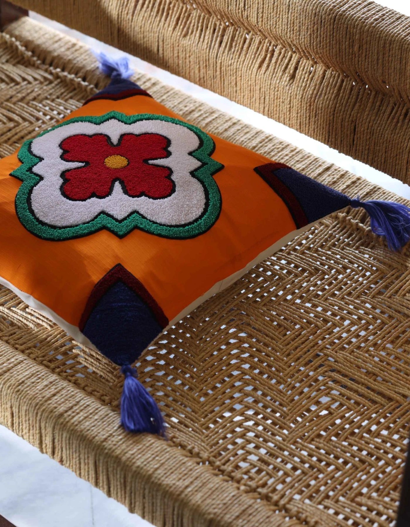 Decorative pillow with a colorful flower design on a woven surface