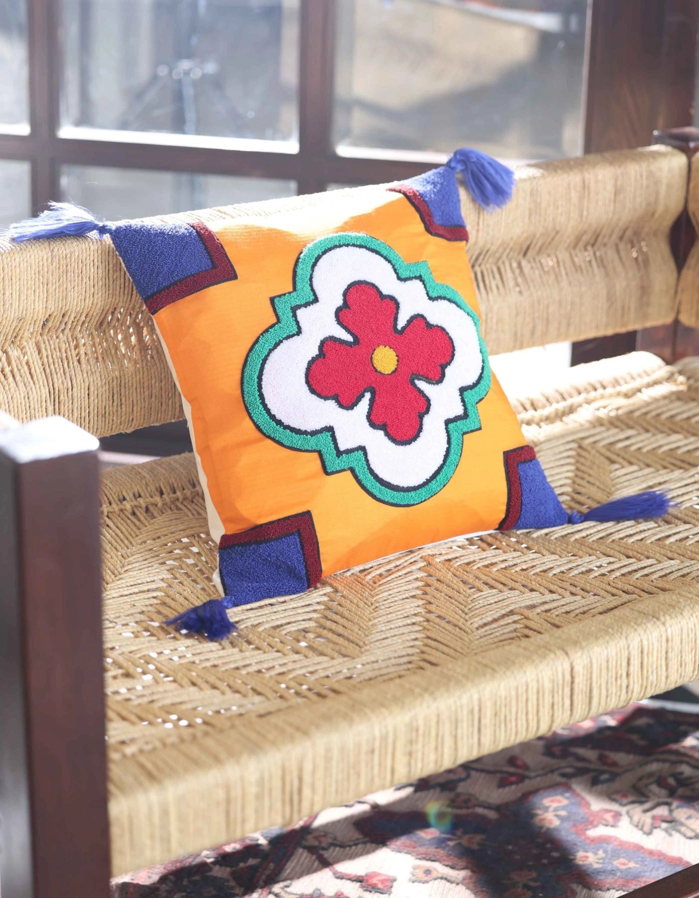 Colorful pillow with a floral design on a woven chair