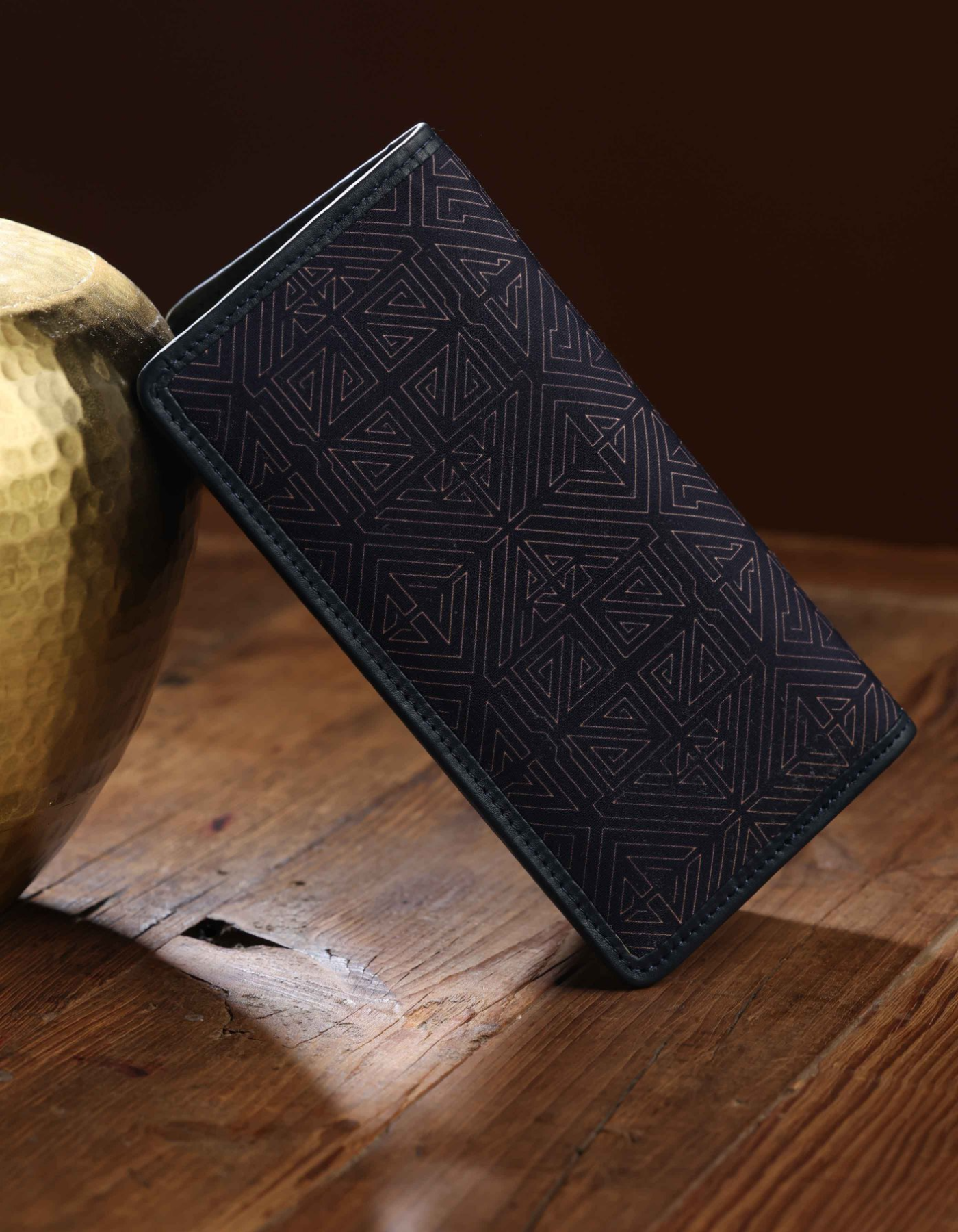 Black textured wallet on a wooden surface
