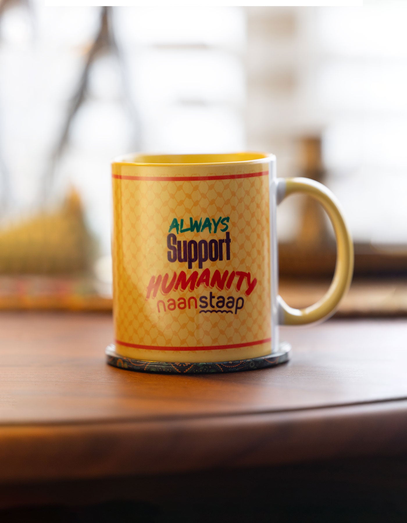 Mug with 'Always Support Humanity' text on a wooden surface