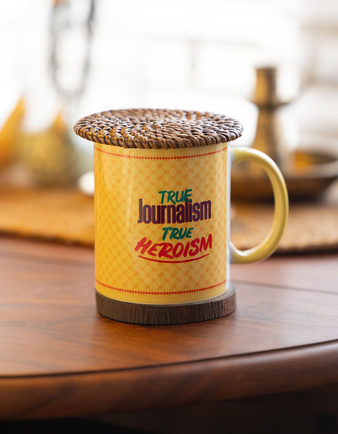 Mug with 'True Journalism True Heroism' text on a wooden surface