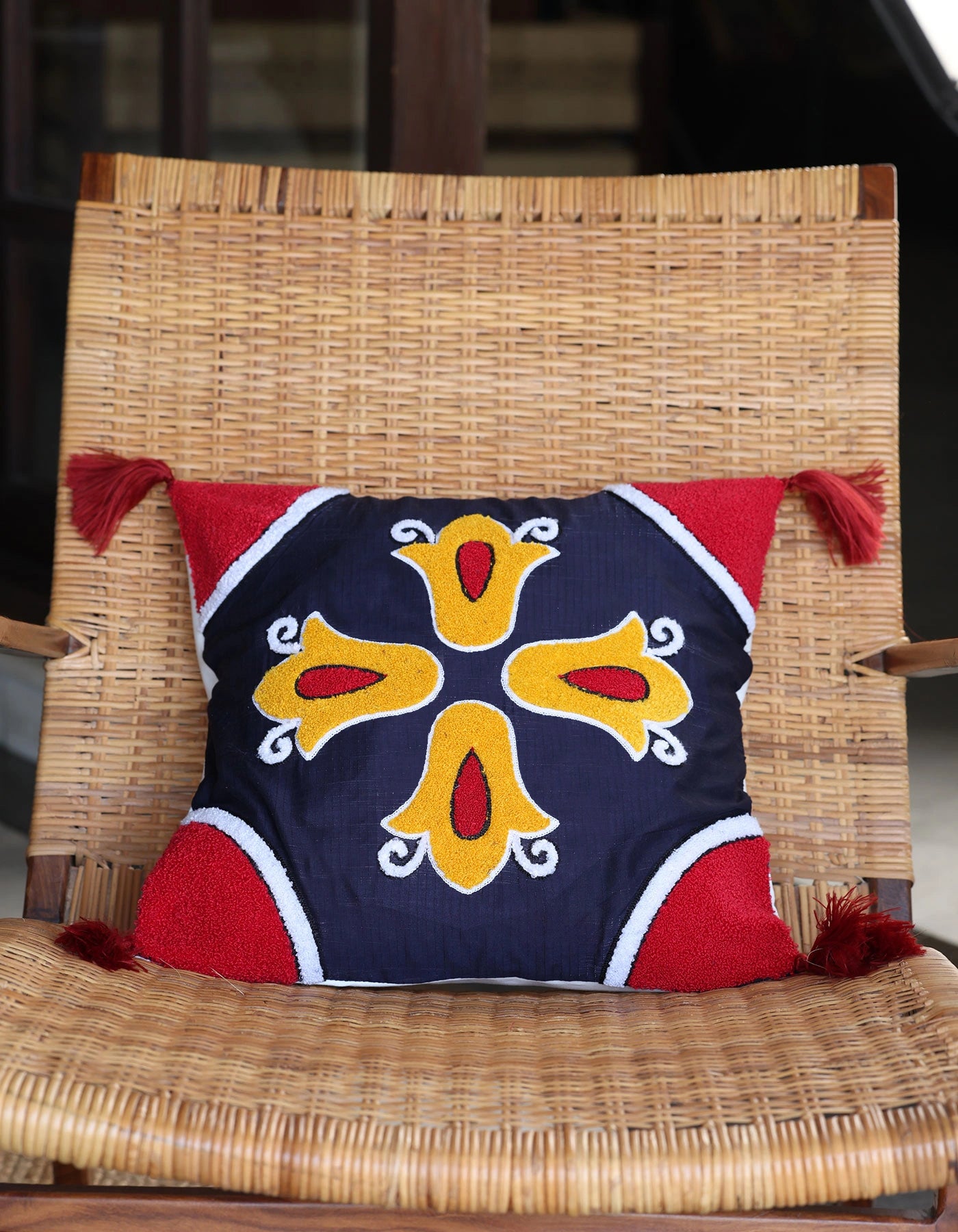 Decorative pillow with a colorful design on a wicker chair