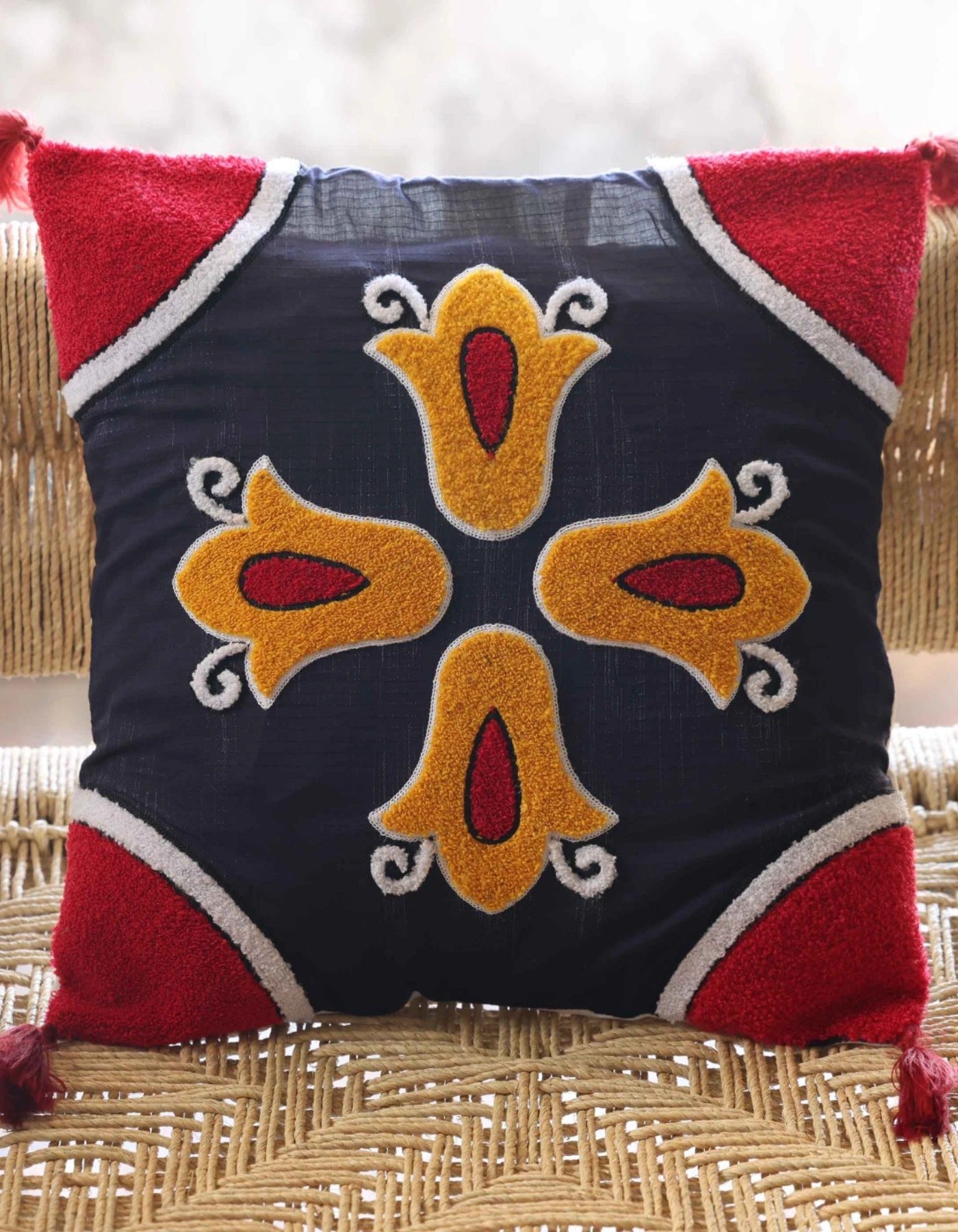 Decorative pillow with embroidered design on a woven surface