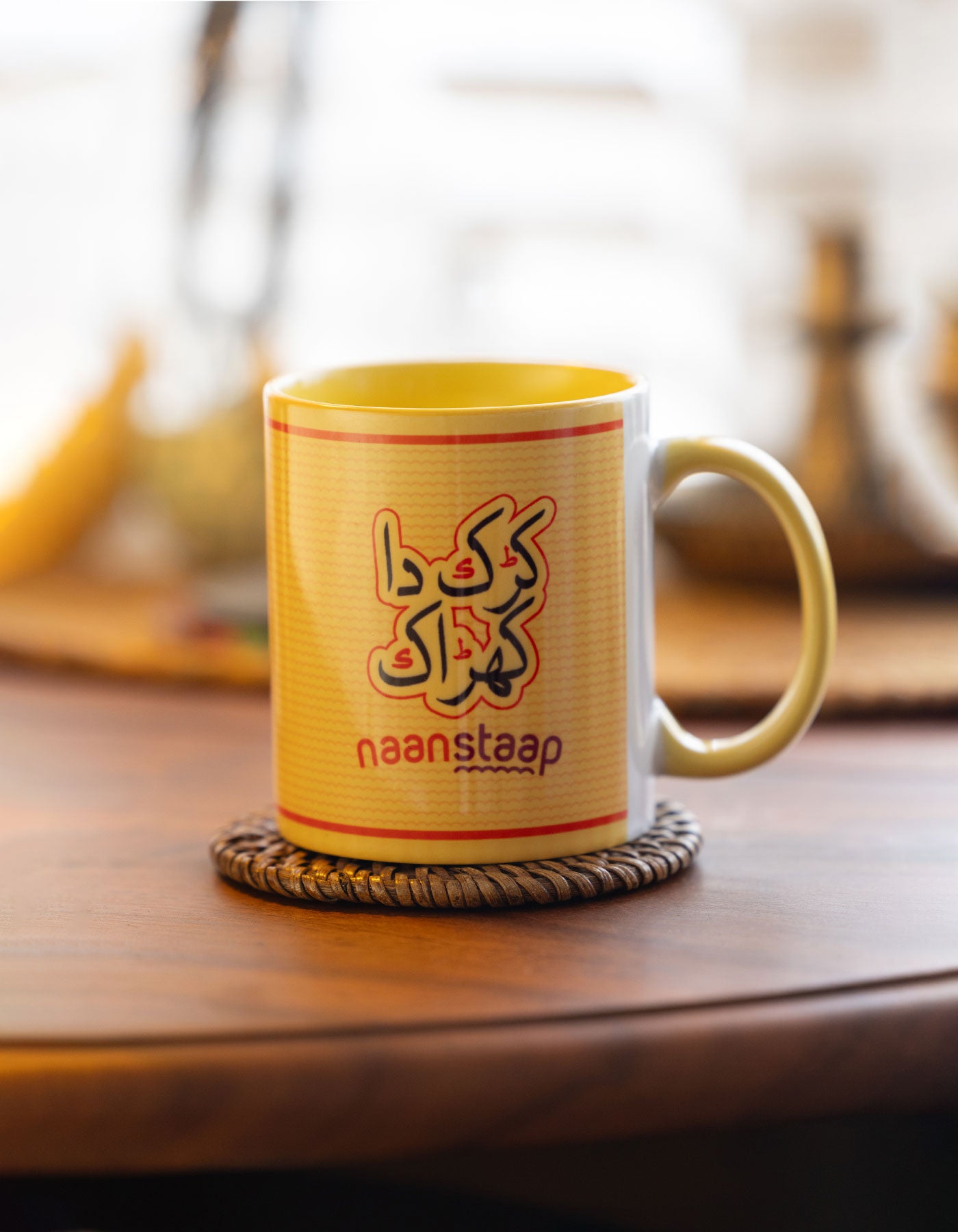 karak da kharrak text Yellow mug with red text on a wooden table